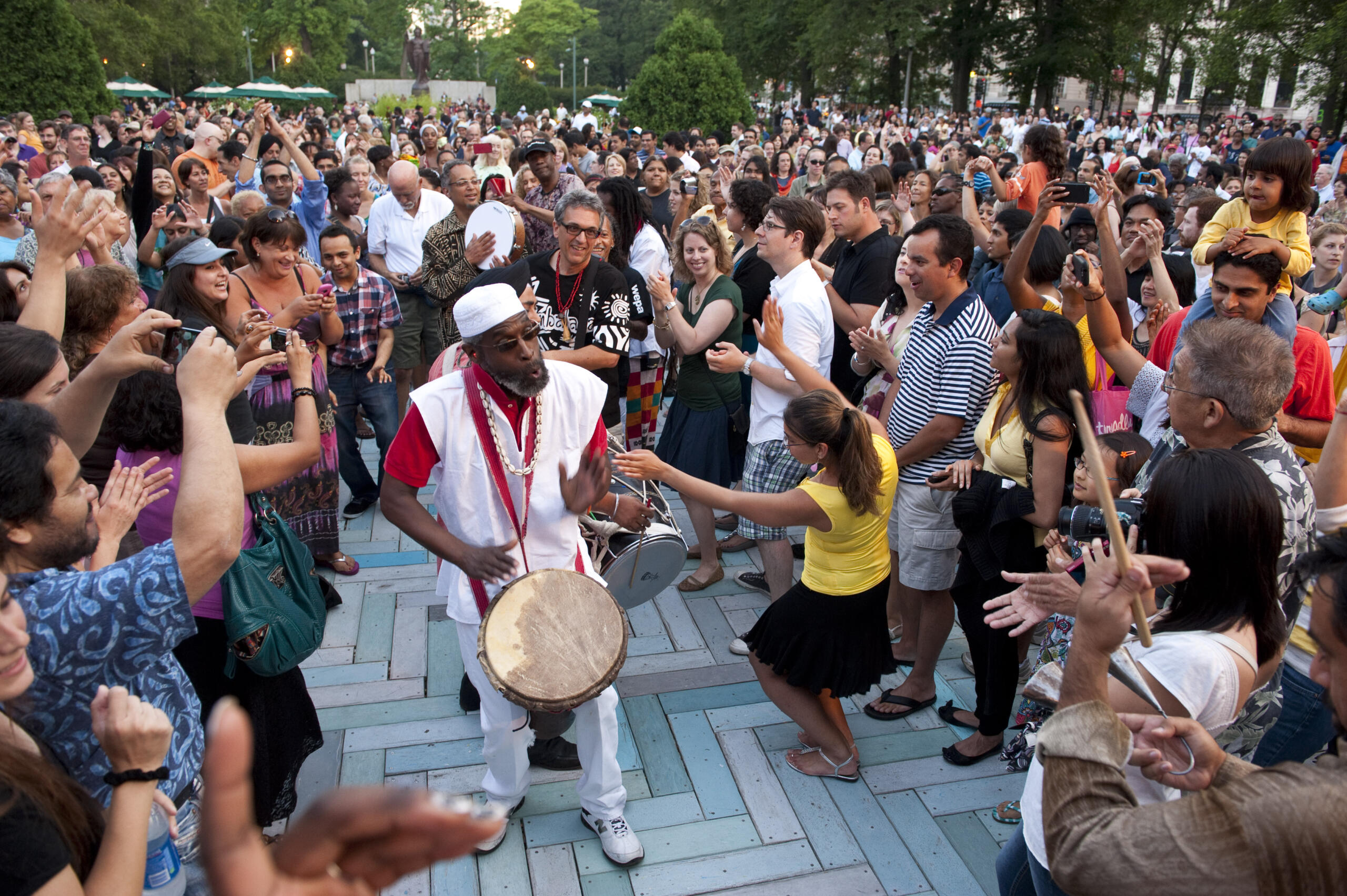 A vibrant crowd dancing around a live drummer at Chicago SummerDance, showcasing high-energy music and community celebration in Grant Park.